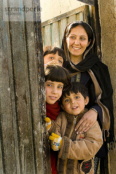 Mutter und ihre drei Kinder vor der Haustür ihres Hauses in Kabul.