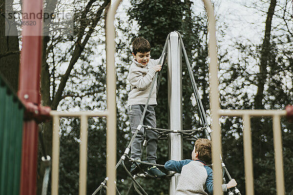 Zwei Jungen spielen auf einem Klettergerüst auf einem Spielplatz