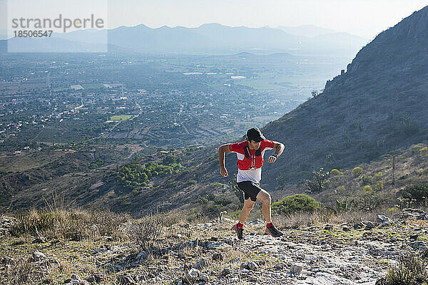 Männlicher Trailrunner klettert die Berge in der Wüstenlandschaft von El Arenal  Hidalgo  Mexiko hinauf.