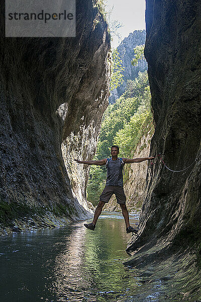 Erwachsener Mann überquert Ramet-Schlucht  Fluss fließt durch die Felsen