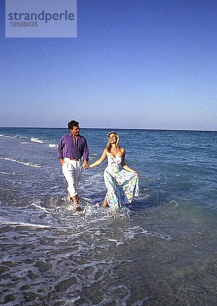 Attraktives junges Paar  das am Strand spaziert
