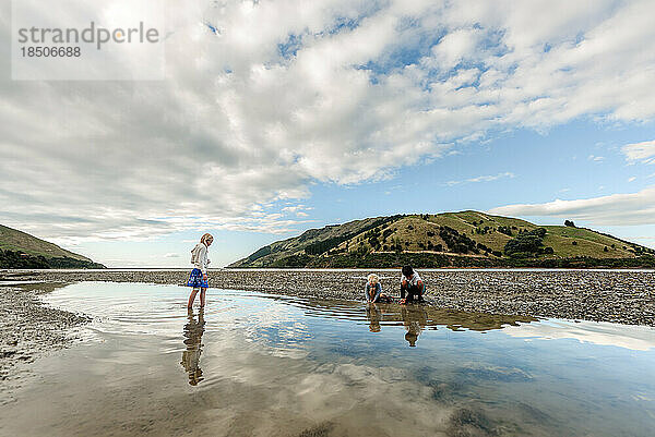Kinder spielen bei Ebbe im seichten Wasser in Neuseeland