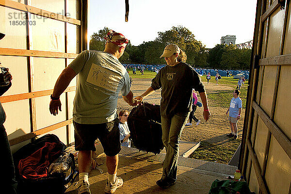 Besatzungsmitglieder laden während des Avon Walk for Breast Cancer in New York City Ausrüstung und Koffer in einen Lastwagen.