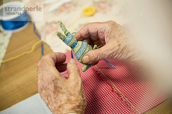Ältere Frau dekoriert Kaninchen aus Stoff