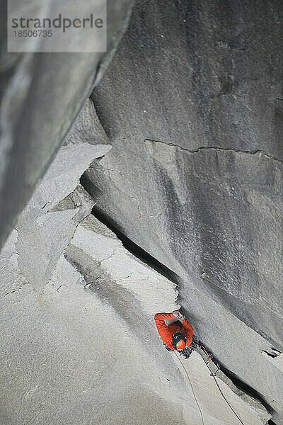 Ein Kletterer erklimmt eine beeindruckend aussehende  zerklüftete Felsformation hoch oben am El Cap