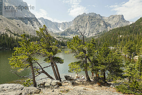 Hikers on shore of alpine lake in Rocky Mountain National Park