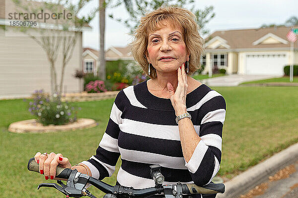 Reife Frau in den Siebzigern genießt einen Tag draußen auf ihrem Fahrrad.