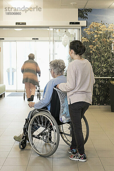 Ältere Frau im Rollstuhl mit Mädchen im Pflegeheim