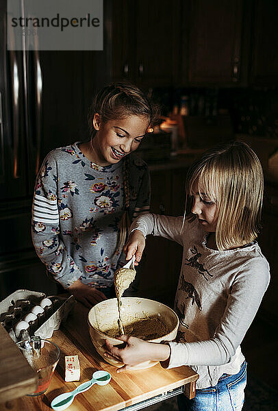 Zwei junge Mädchen backen in der Küche