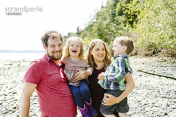 Geradeaus Nahaufnahmeporträt einer glücklichen vierköpfigen Familie an einem sonnigen Tag