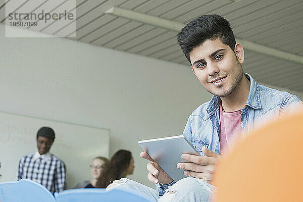 Universitätsstudent mit einem digitalen Tablet im Klassenzimmer einer Schule  Bayern  Deutschland