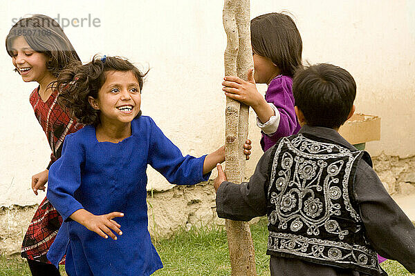 Kinder lachen und spielen im Hof ??ihres Hauses in Kabul.