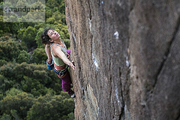 Eine Kletterin kreidet die Wand an und untersucht sie  bevor sie ihre nächsten Schritte an den Orgelpfeifen am Mt. Wellington in der Nähe von Hobart  Tasmanien  macht.
