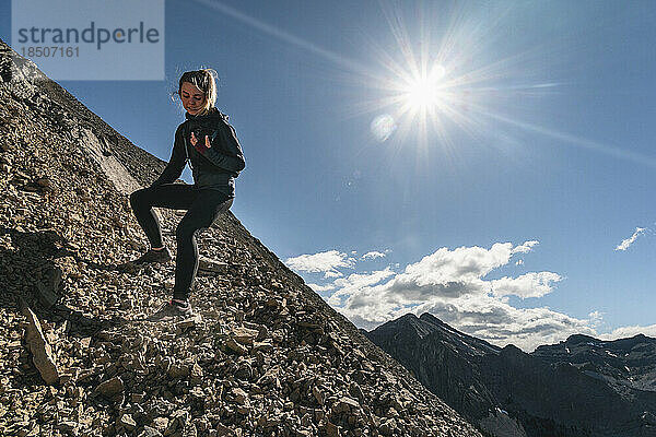 Weibliche Trailrunnerin klettert den Yamnuska-Berg hinunter