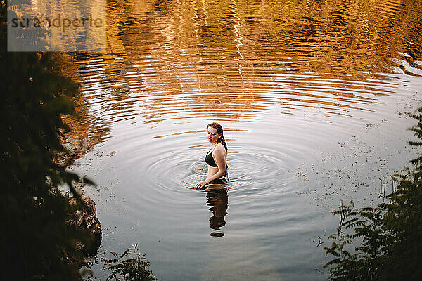 Junge Frau im Bikini steht im See