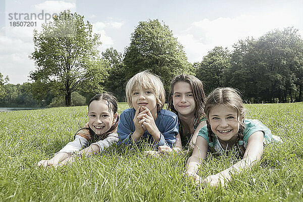 Gruppe von Freunden  die auf Gras in einem Park liegen  München  Bayern  Deutschland