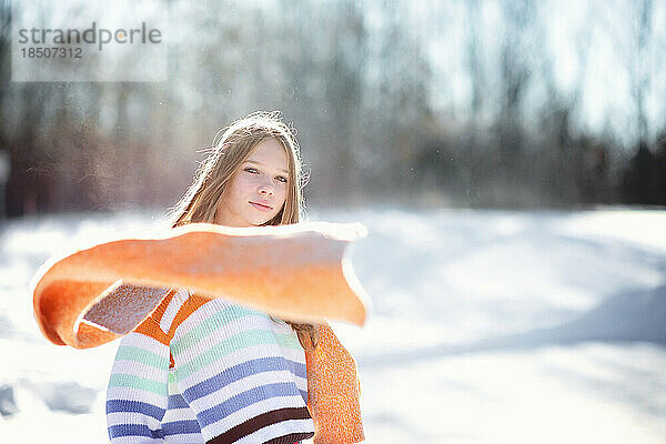 Schönes Teenager-Mädchen mit gelbem Schal draußen im Schnee.