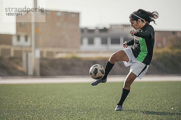 Lateinamerikanische Fußballspielerin  die den Ball tritt