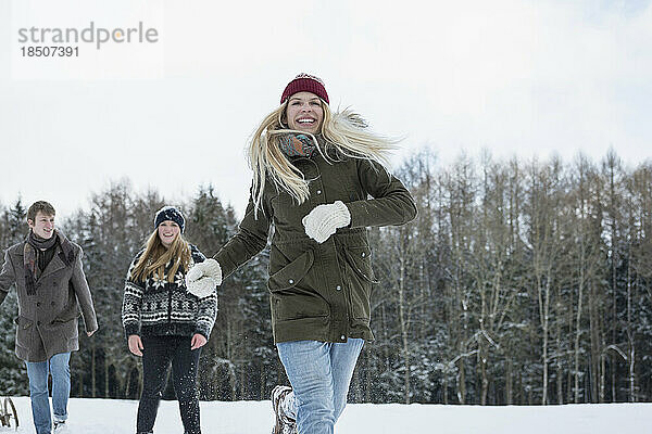 Freunde laufen im Winter in verschneiter Landschaft  Bayern  Deutschland