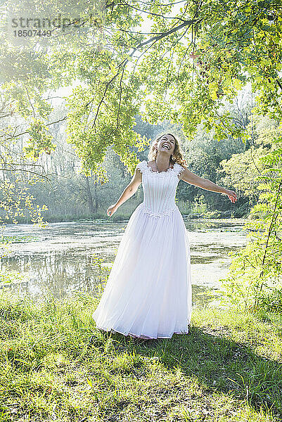 Blick auf eine schöne Braut  die am See tanzt und lacht  Deutschland