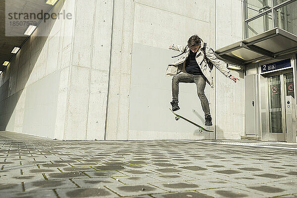 Junger Mann springt mit Skateboard in der Luft  München  Bayern  Deutschland