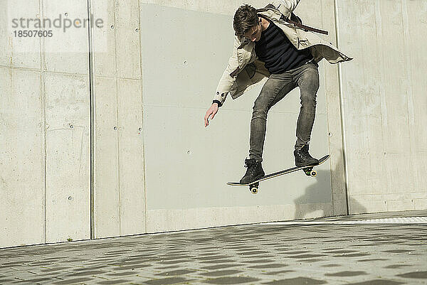 Junger Mann springt mit Skateboard in der Luft  München  Bayern  Deutschland