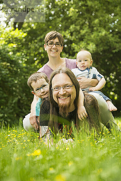 Glückliche Familie  die im Garten liegt