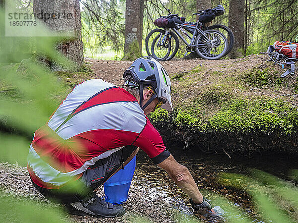 Mountainbiker rastet am Bach im Schwarzwald  Baden-Württemberg  Deutschland