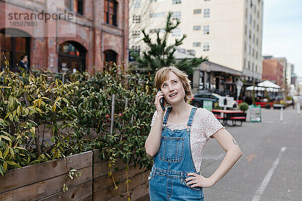 Nachdenkliche Frau telefoniert  während sie außerhalb der Innenstadt spazieren geht