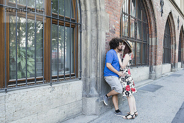 Junges Paar küsst sich draußen in der Stadt