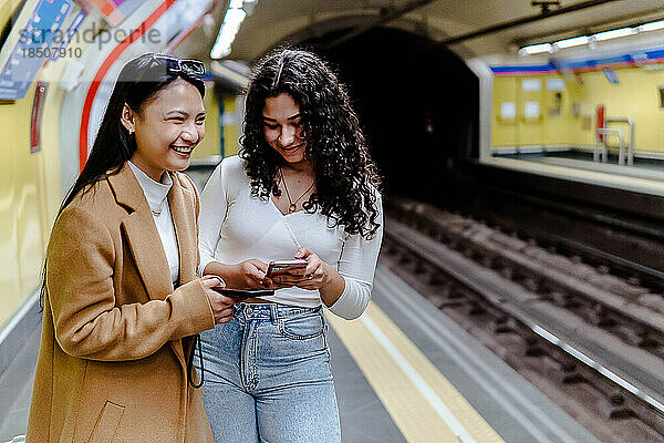 Stockfoto von zwei Mädchen  die das Handy in der U-Bahn benutzen