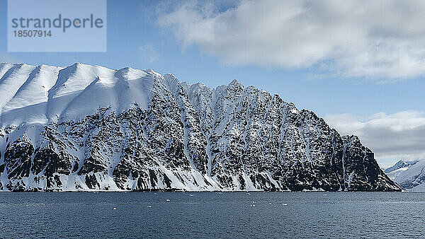 Schneebedeckte Berge geformte Welle unter einem blauen Himmel