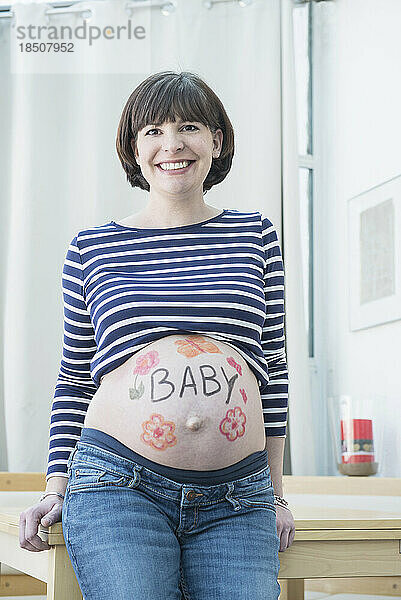Porträt einer schwangeren Frau mit Design auf dem Bauch