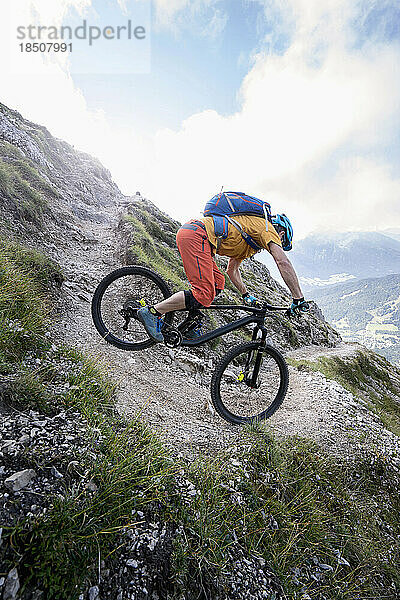 Mountainbiker fährt eine enge Kurve bergab  Tirol  Österreich