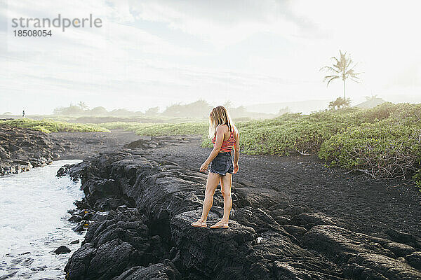 Ein Mädchen läuft auf Lavafelsen in der Nähe des Ozeans  Big Island  Hawaii.