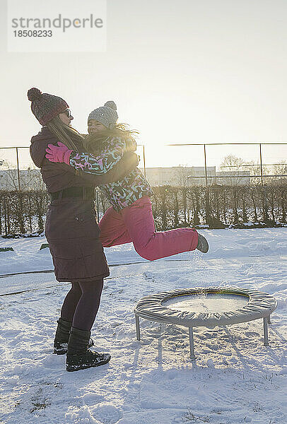 Mädchen springt mit ihrer Mutter auf Trampolin