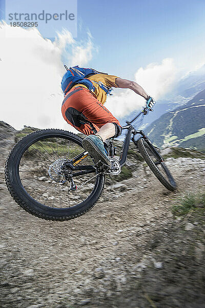 Mountainbiker fährt eine enge Kurve bergab  Tirol  Österreich