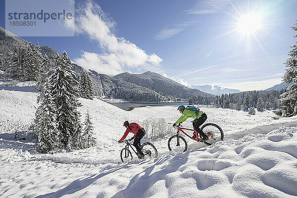 Mountainbiker bewegen sich auf einem schneebedeckten Berg hinunter