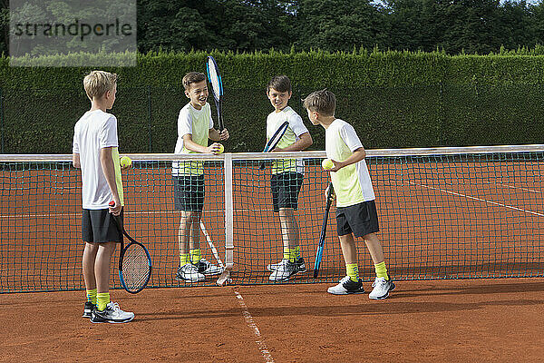 Junge Jungs spielen Tennis an einem sonnigen Tag  Bayern  Deutschland