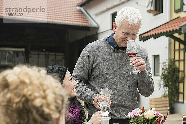 Reifer Mann probiert Wein beim Picknick auf einem Bauernhof  Bayern  Deutschland