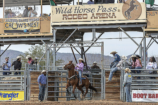 A female rider blasts into the ring for the rodeo barrel racing event