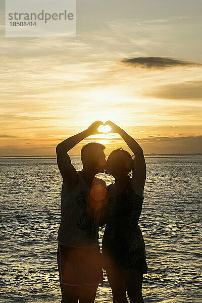 Silhouette eines Paares  das mit den Händen eine Herzform macht  Nusa Lembongang  Bali  Indonesien