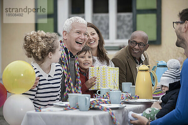 Großvater mit seiner Familie lacht auf seiner Geburtstagsfeier  Bayern  Deutschland