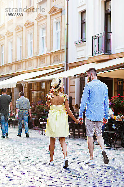 Verliebte Paare gehen im Sommer mitten in der Stadt spazieren