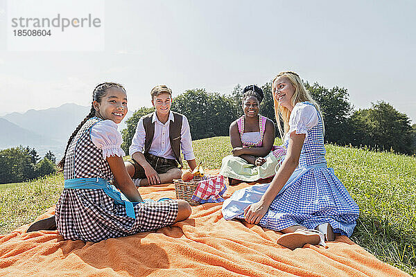 Fröhliche Teenager-Freunde entspannen auf einer Picknickdecke  Bayern  Deutschland