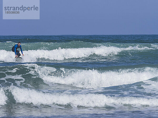 Junger Mann surft am Strand von Sopela  Biskaya  Baskenland  Spanien