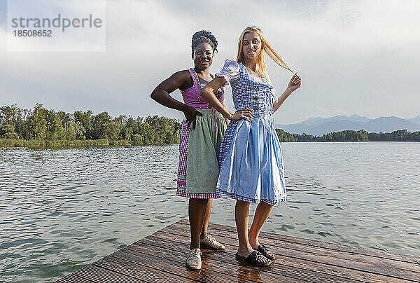 Teenager-Freunde stehen am Pier über dem See  Bayern  Deutschland