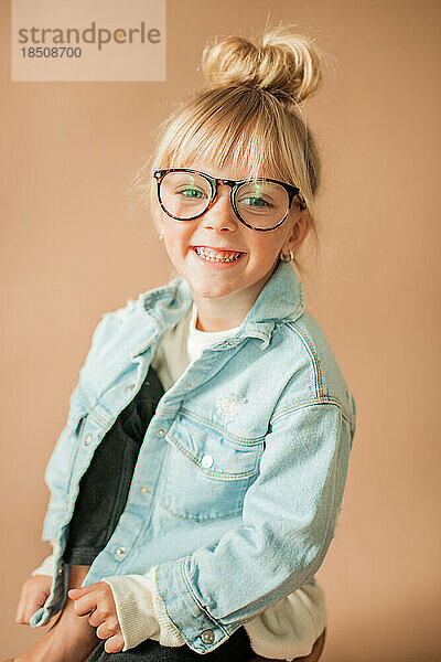 Fröhliches Porträt eines süßen kleinen Kleinkindmädchens mit lächelnder Brille