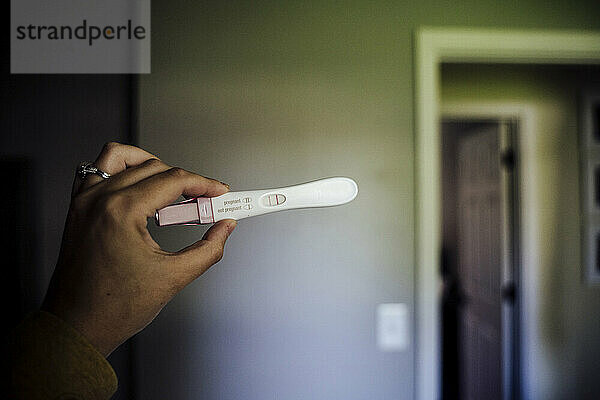Positive Pregnancy Test Held by Woman's Hand