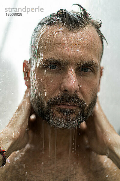 Mann mittleren Alters unter der Dusche  Wassertropfen.